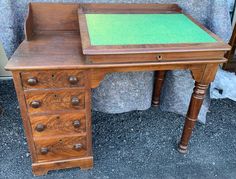 an old wooden desk with green glass top