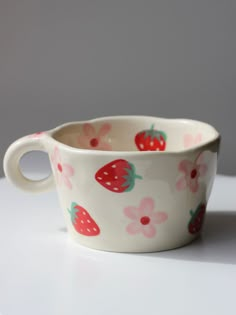 a cup with strawberries on it sitting on a table