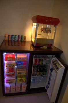 a small refrigerator with drinks and sodas in it's display case next to a mini fridge