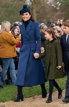 the duke and princess of cambridge walk hand in hand with children at an outdoor event