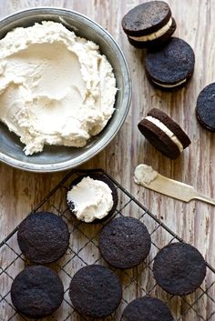 chocolate cookies and ice cream on a cooling rack next to a cookie tin with oreo cookies