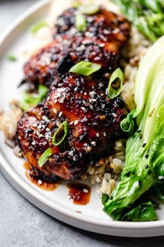 a white plate topped with chicken and broccoli covered in sesame seed flakes