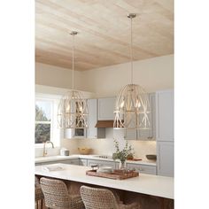 a kitchen with white counter tops and wooden ceiling lights hanging from the ceiling above it