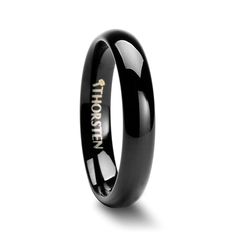 black ceramic ring with gold lettering on the side and an inscription engraved on the inside