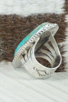 This turquoise and sterling silver ring was made by Navajo silversmith Leslie Nez. The inside is signed Leslie Nez and stamped sterling.Size: 10.5Length: 2 1/4"Width: 7/8"Free shipping on all orders! We ship with USPS and always include tracking. All orders ship within a day of payment.Returns are accepted up to 30 days after you receive your order. Just send us a message. Our shop offers cash back or store credit. The item must be returned in new condition. Adjustable Engraved Turquoise Ring, Western Sterling Silver Turquoise Ring With Patina, Western Style Stamped Turquoise Ring Gift, Unique Stamped Turquoise Ring, Native American Jewelry, Turquoise Sterling Silver, Free Jewelry, Sterling Silver Ring, Cuff Bracelets