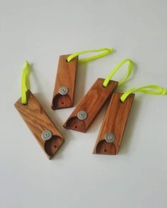 four pieces of wood with neon yellow string attached to them on a white surface,