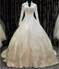 a white wedding dress on display in front of a black curtain with the words, we are