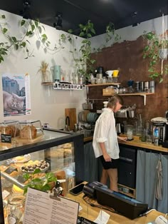 a woman standing in front of a counter filled with food