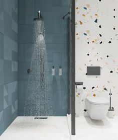 a shower head in the middle of a bathroom with blue tiles on the walls and floor