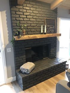 a living room with a brick fireplace and wooden floors