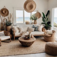 a living room with wicker furniture and large windows overlooking the ocean is shown in this image