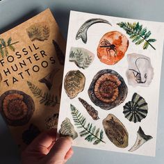 a person holding up a book about fossil hunter tattoos