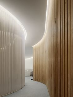 a curved room with wooden slats on the walls and carpeted flooring in front of it