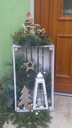 a white lantern sitting on top of a christmas tree in front of a wooden door