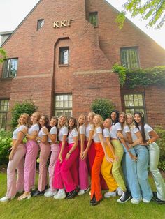 a group of young women standing next to each other in front of a brick building