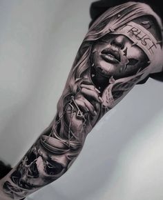 a man's arm with an image of a woman holding a scale and money on it