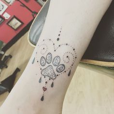 a dog paw tattoo with hearts and drops