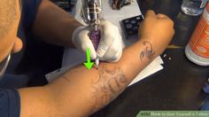 a tattoo artist getting inked on someone's arm with green arrow pointing to it