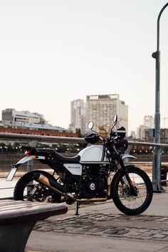 a motorcycle parked on the side of a road next to a bench and street light