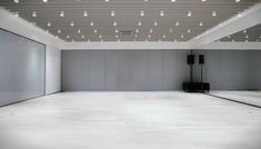 an empty room with white walls and lights on the ceiling is seen in this image