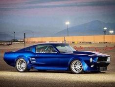 a blue mustang sitting on top of an airport tarmac