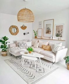 a living room filled with white furniture and lots of greenery on the wall next to it