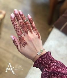 a woman's hand with henna tattoos on it