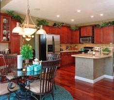 a kitchen and dining room with wood floors, cabinets, and an island in the middle