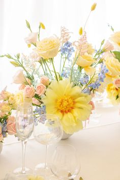 the table is set with flowers and wine glasses for guests to sit down at it