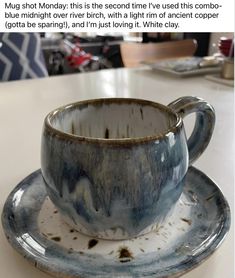 a dirty cup and saucer sitting on top of a table next to an empty plate