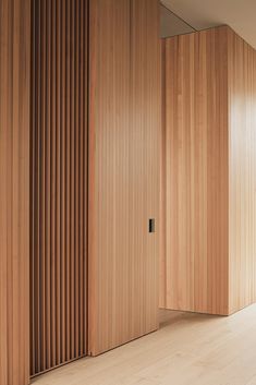 an empty room with wooden slats on the walls