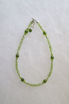 This anklet combines Sterling Silver, Swarovski Crystal and green Peridot gemstones. Peridot is the gemstone for the month of August. This is the stone of compassion. It is also believed to bring good health, restful sleep and peace to relationships by balancing emotions and mind. It has the ability to inspire eloquence and creativity and brings delight and good cheer. The anklet has a 1" extension with a beaded drop making it adjustable. Anklets usually fits sizes 9.75" - 11".  Custom Orders are always welcome! Elegant Green Anklet For Gifts, Elegant Green Anklets For Gift, Balancing Emotions, Month Of August, Providence Ri, Good Cheer, Peridot Gemstone, Green Peridot, Restful Sleep