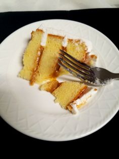 a piece of cake on a white plate with a fork in it and another slice missing