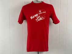 "Vintage 1980s t-shirt. Made of red cotton. Has white heart graphics: TICKER CLUB KEEP ON TICKIN'. Made by Hanes Beefy t. Size Medium. Actual measurements are:   37\" around the chest  37\" around the waist  18.5\" shoulder seam to shoulder seam  29\" overall length  In very good condition, with tiny hole and tiny spot lower front, see picture." Cheap Vintage T-shirt With Heart Graphic, American Style Red Graphic Print T-shirt, Vintage Red T-shirt With Text Print, Retro Cotton T-shirt With Heart Graphic, Red Cotton T-shirt With Heart Print, Heart Tshirt, Heart Graphics, Club T Shirt, Red T Shirt