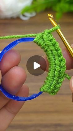 someone is crocheting the end of a piece of yarn with a pair of scissors