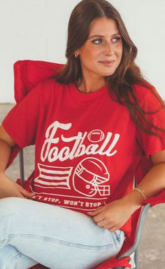 a woman sitting in a chair wearing a football t - shirt