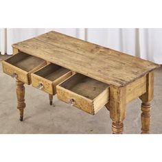 an old wooden table with three drawers