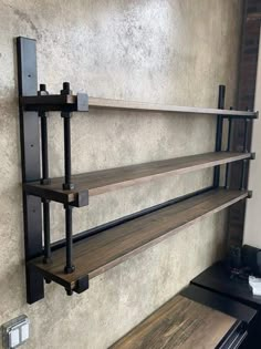 three wooden shelves with metal brackets on the wall