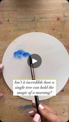 someone is painting a plate with blue paint on it and the caption reads, isn't it incredible how a single tree can hold the magic of a morning?