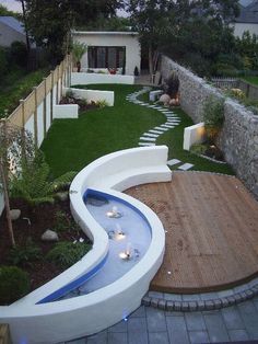 a backyard with a wooden deck and water feature