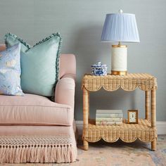 a living room with a couch, table and lamp next to each other in front of a blue wall