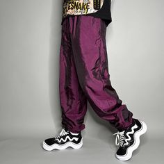 "Vintage Track Pants Purple Nylon Chameleon Joggers Baggy Fit Elastic Cuffs has Ankle Zippers Lined 90s Skate / Streetwear Great Condition: 9/10 Men's Size: X-Large My Hands in Pockets = It has Pockets No Hands in Pockets = Does Not Have Pockets Drawstring Will be Visible in Forward Pic, if not Visible it Does Not Have a Drawstring About me: I am 6' 0\" for reference I generally wear a Large (32\" inseam) I Model XS to 2XL sweatpants, I find that you can often size up or down with 95% of sweatpants and they fit the same" Retro Winter Streetwear Bottoms, 90s Style Summer Streetwear Pants, Hip Hop Parachute Pants With Elastic Waistband For Spring, 90s Baggy Parachute Pants For Spring, 90s Style Pants For Streetwear In Fall, 90s Style Pants For Fall Streetwear, 90s Style Fall Streetwear Pants, Stretch Parachute Pants For Hip Hop Streetwear, Retro Stretch Pants For Streetwear