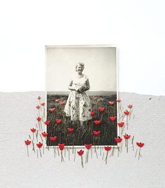 a woman standing in a field with red flowers