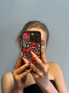 a woman holding up her cell phone to take a selfie in front of her face