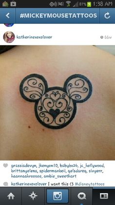 mickey mouse tattoo on the back of a woman's shoulder