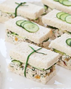 cucumber sandwiches are arranged on a white plate