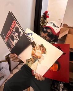 a man holding up two posters with his hands