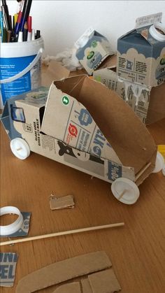 some cardboard boxes sitting on top of a wooden table next to scissors and other crafting supplies