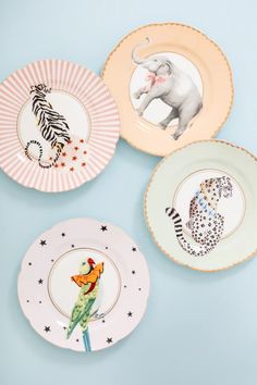 four plates with animals painted on them and one has an elephant, zebra, giraffe