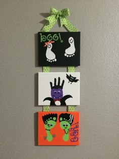 three magnets are hanging on the wall with green and orange decorations, one is for halloween